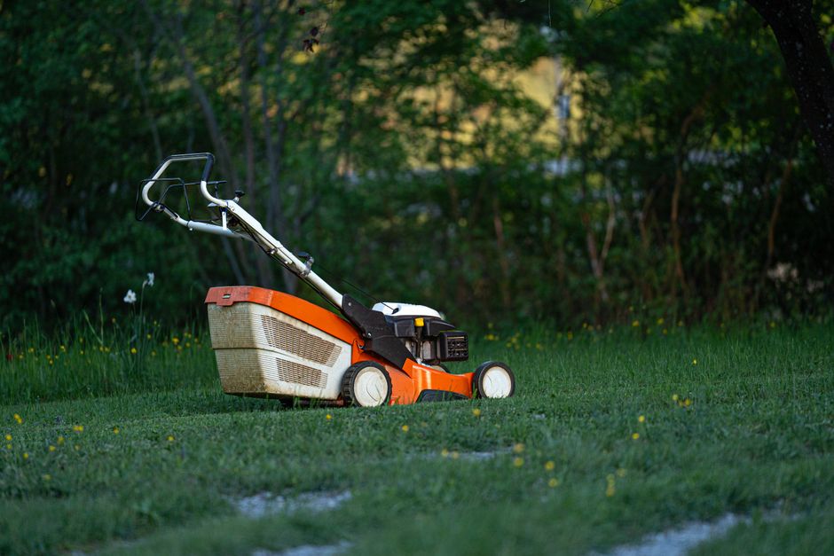 Lawn mower on green grass illustrating summer lawn care in Richmond, VA.