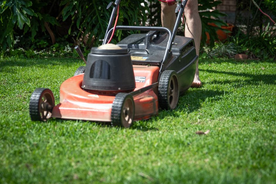 Lawn mower cutting grass in Richmond, VA, for healthy lawn maintenance.