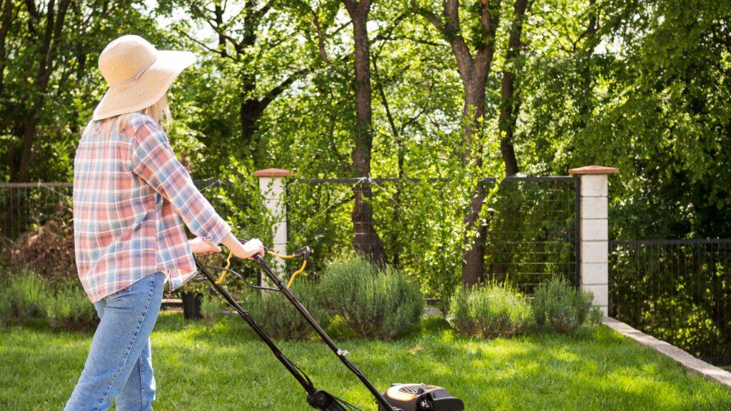 Organic weed control in Richmond, VA with a homeowner mowing a healthy green lawn using eco-friendly lawn care practices.